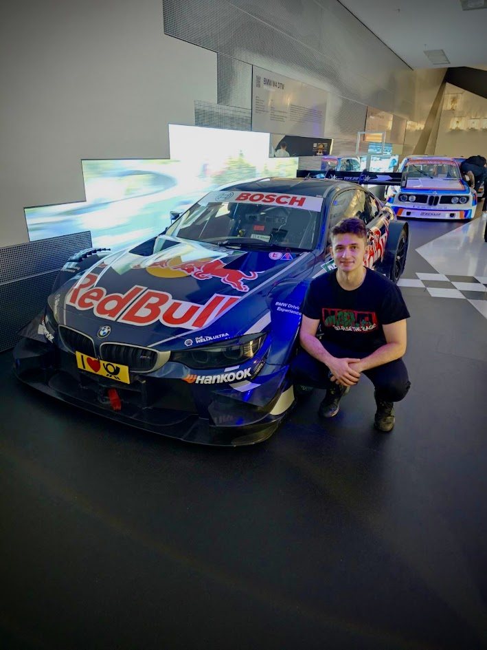 Marian Barbieru 蹲在一辆 Red Bull BMW M4 DTM 赛车旁