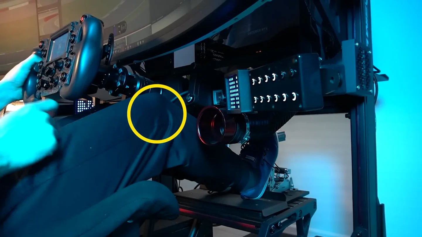 Side view of a driver seated in a sim rig with a yellow circle around the knee showing the slight bend to keep when the brake pedal is fully pressed, part of the brake pedal settings sim racing position check.