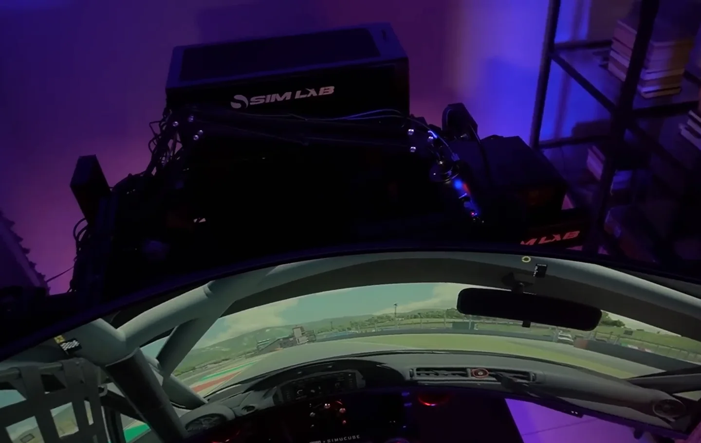 A Sim Lab PC case sitting on a shelf mounted behind and above the rig's curved monitor, one of the organisation-focused sim racing accessories.