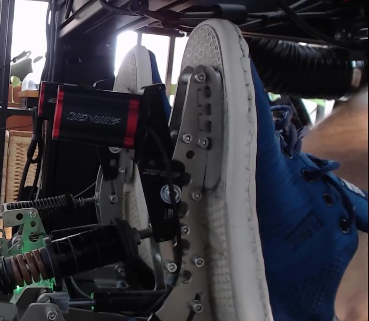 Side view of a left foot pressing squarely into the brake pedal face, the perpendicular press from these sim racing brake pedal tips.