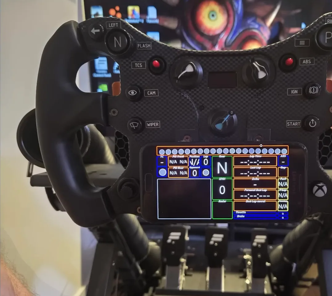 A Fanatec McLaren wheel on a rig with an old phone mounted just below the centre hub running a SimHub dash, one of the cheap sim racing mods from the video.