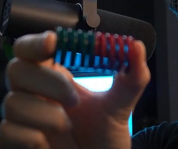 A green and a red metal brake pedal spring stacked end to end and held up to the camera, the two-stiffness combination among these cheap sim racing upgrades.