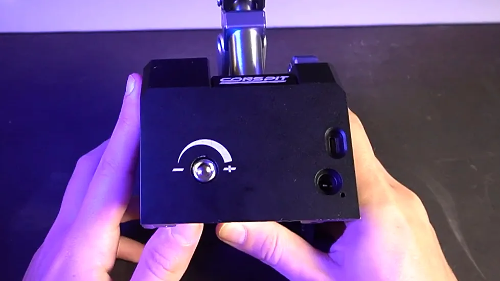 Adjustment dial with a minus to plus scale on the end of the Conspit CHS shifter base, held up in two hands