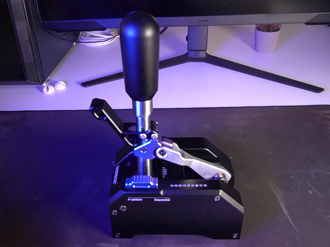 Conspit CHS dual-mode shifter on a desk, seen from slightly above: knob, shaft, lever mechanism and a base marked H-pattern and Sequential