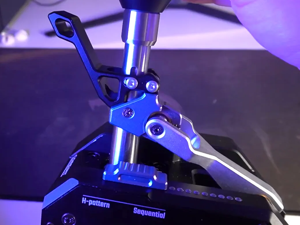 Conspit CHS mode selector close-up: H-pattern and Sequential labels on the base below the ridged slider and the lever mechanism