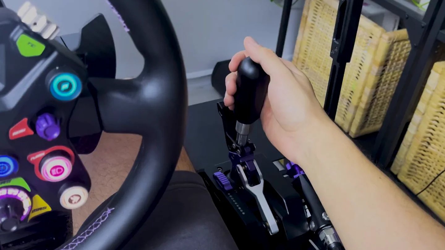 Conspit CHS H-pattern shifting from the driver's seat, right hand gripping the black knob beside the steering wheel rim