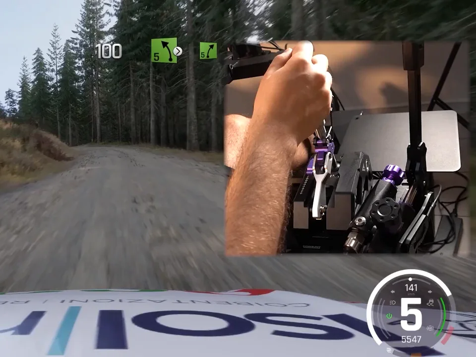 Conspit CHS sequential shifting on a rally stage: inset of the driver's hand on the shift knob over an in-game gravel forest road
