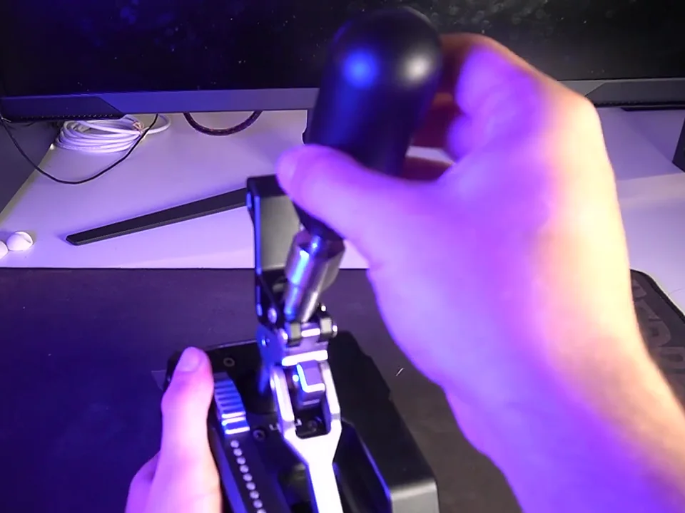 Shift knob being twisted by hand on the Conspit CHS, with the metal shaft it screws onto visible just below the knob