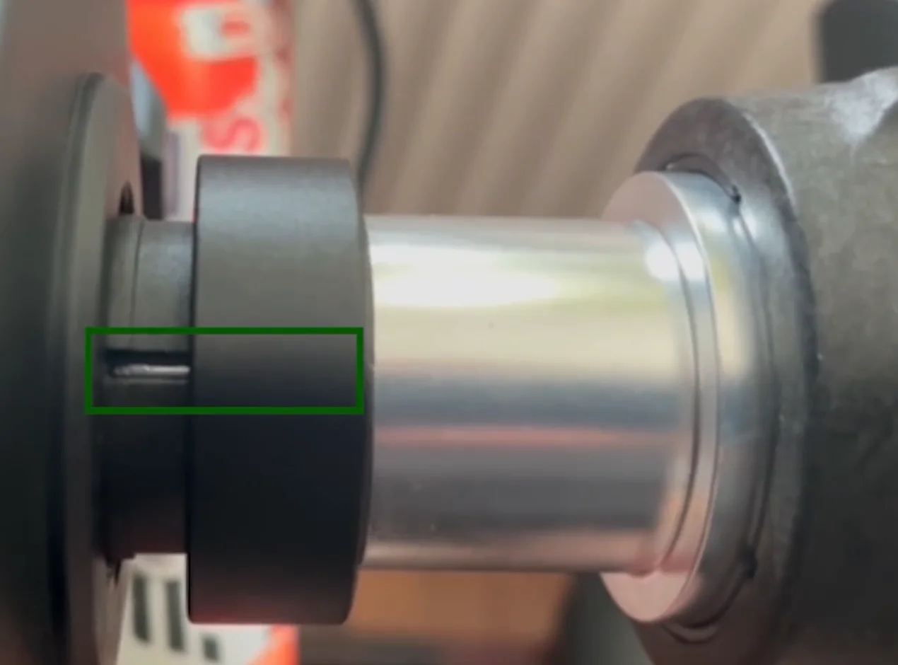 A green box highlights the area on a Fanatec CSL DD base where the retaining ring and the shaft meet.