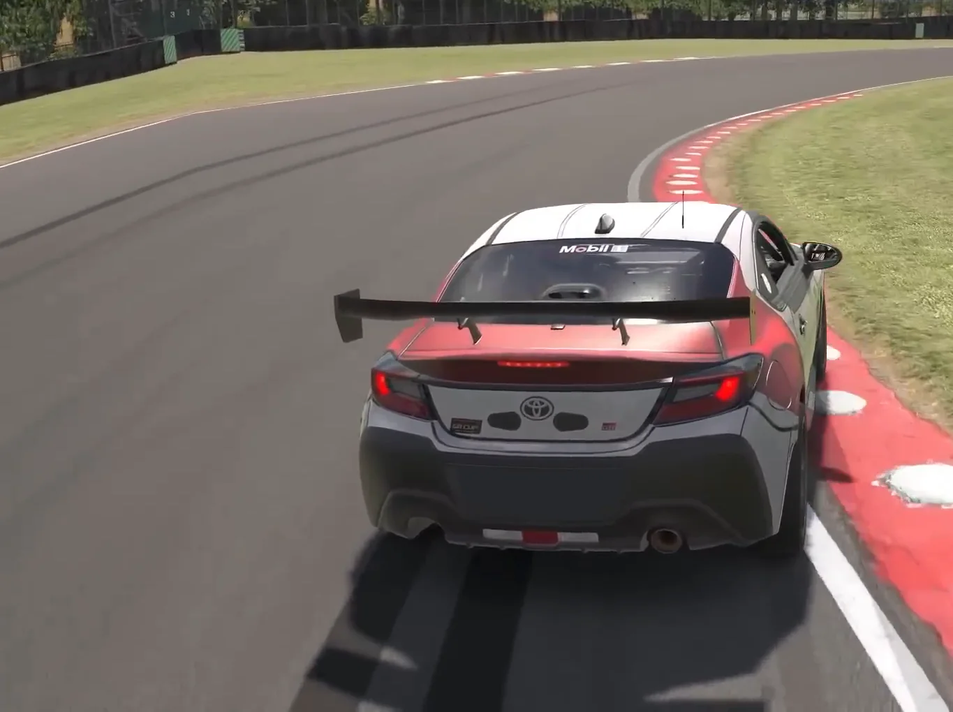 Chase camera of a Toyota GR86 with its brake lights on, rotating hard towards the inside kerb because the brake pressure was held into the corner, showing what trail braking in sim racing does to the rear of the car.