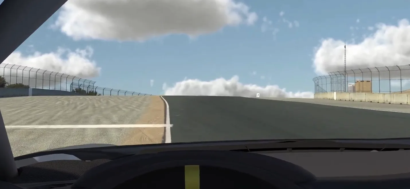 Cockpit view of a track climbing to a crest, one of the racing corner types, with the road surface vanishing against the sky over the top.