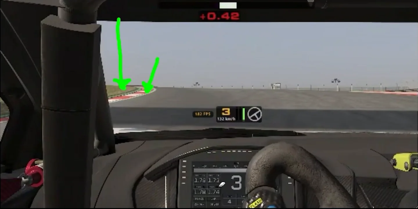 Cockpit view on the coach's screen with two green arrows drawn at the crest of a corner marking where Jason was looking and where to look instead, the vision problem behind his sim racing braking mistakes.