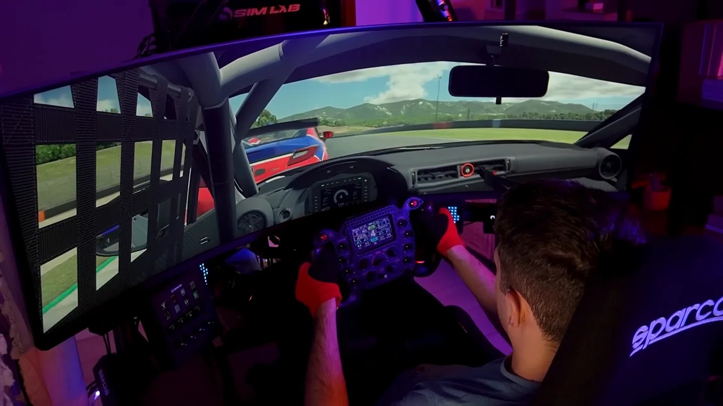 The single curved screen and cockpit used for the sim racing head tracking test, seen from behind the driver's seat.