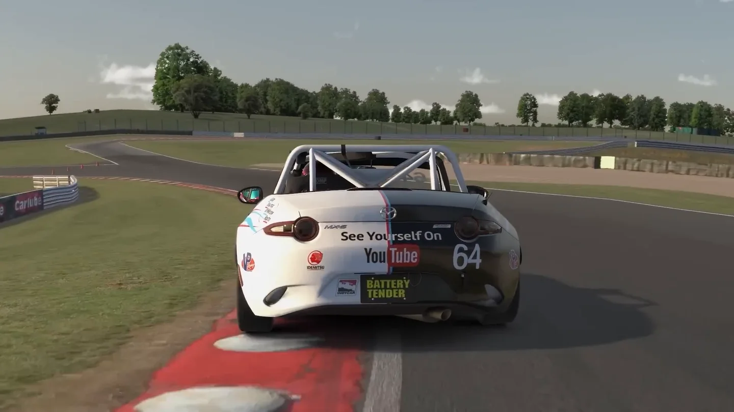 一台 Mazda MX-5 的左侧车轮压在红白路缘石上，用尽模拟赛车进步所要求的整个赛道宽度。