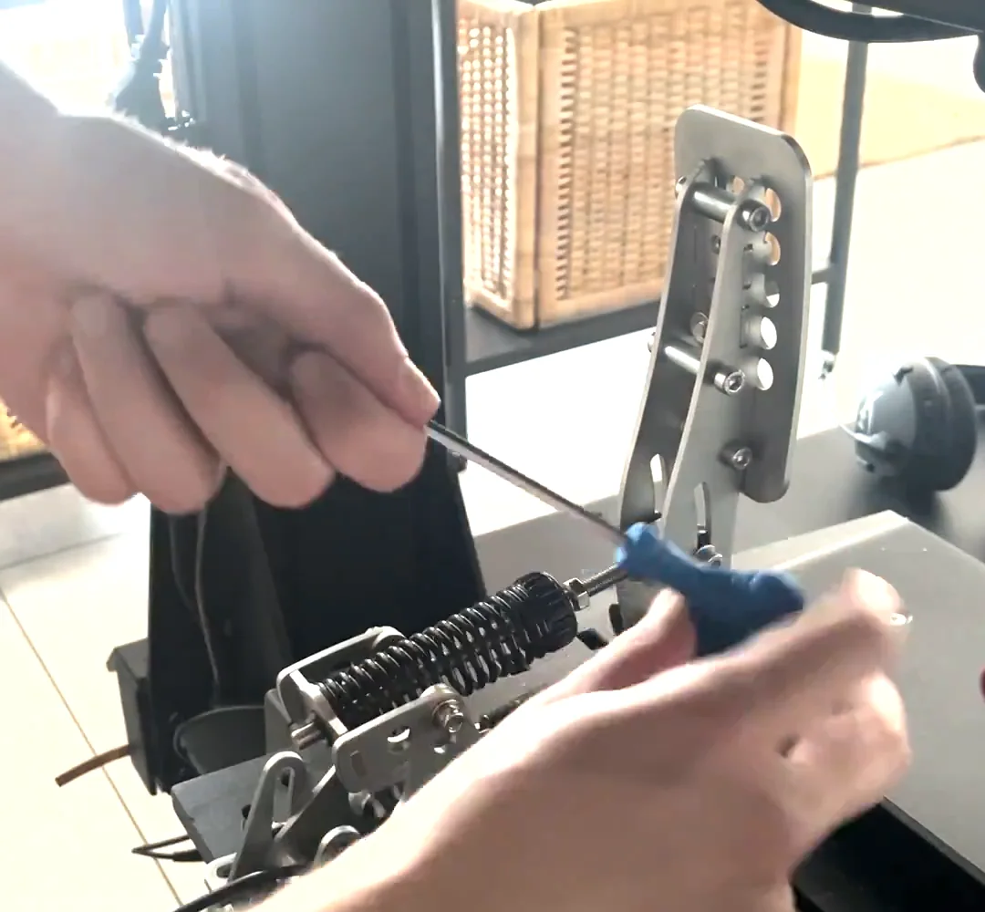 An Allen key removing the existing bolt from the Heusinkveld pedal arm, the step in a Simagic haptic reactor Heusinkveld mount where the pedal's own bolt comes out.